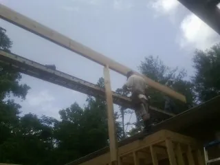 Carpenter setting a ridge beam over a new addition frame — Ice Dam Removal by Roofing Brothers in Portersville