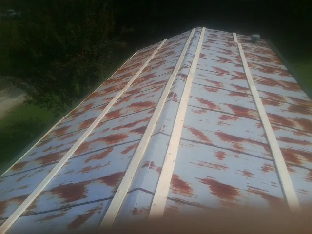Rusted metal roof panels with new wood purlins before replacement — Storm Damage Roof Repair in Portersville by Roofing Brothers