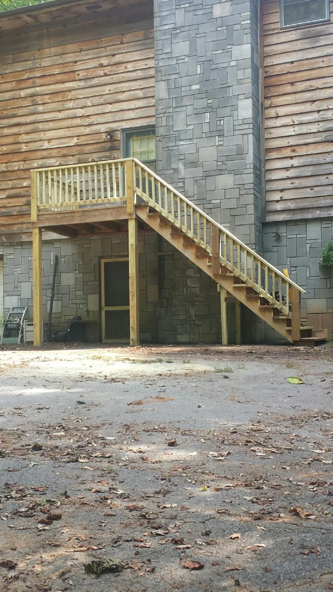 New pressure treated deck and stair landing on a log home in Portersville