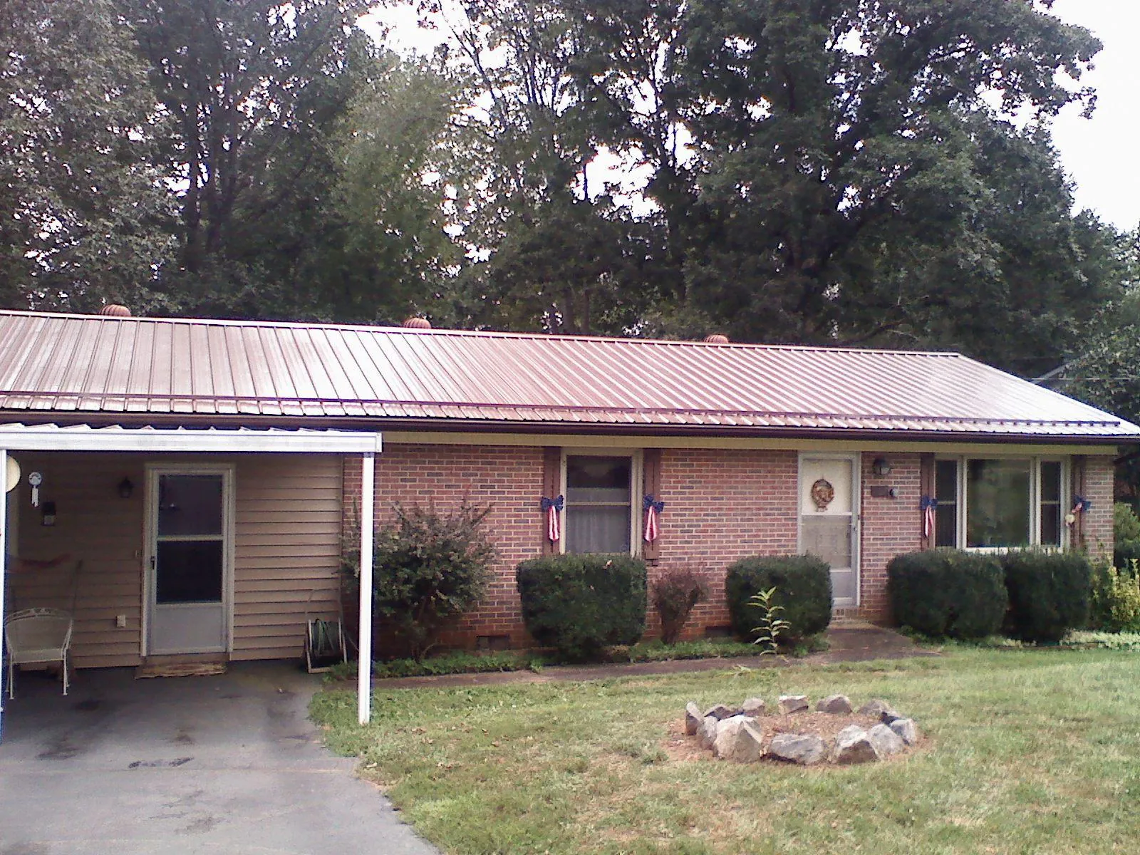 Bronze metal roof and carport on a brick ranch home — Roof Repair work by our crew in Portersville